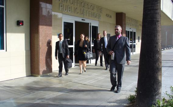 A group of deputy public defenders walk in front of the office