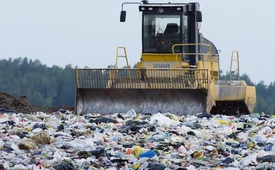 Bulldozer moves trash at a landfill